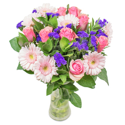 Crafted just steps from Lee Green's historic avenues, this bouquet infuses the spirit of local blooms and the soft optimism of spring mornings. Pale pink gerberas, arranged with a gentle hand, open like delicate fans alongside classic pink roses, their spiral petals glowing with a romantic blush. Flashes of purple statice weave a lively, cheerful rhythm through the arrangement, their textural presence reminiscent of vibrant market bunches from local flower stands. Underneath, the foliage is deep green and dewy, adding an invigorating freshness that grounds the airy, luminous blossoms above. Housed in a simple glass vase, the stems are clearly visible in sparkling water, inviting thoughts of same-day delivery fresh from Flowers Lee to your home or office. The entire ensemble glows softly, evoking the atmosphere of Lee's tranquil gardens in the first light of day. Ideal for a get-well-soon bouquet, a birthday surprise, or a bright accent for a local workspace, this arrangement radiates meticulous care. Every detail, from the velvet touch of the petals to the buoyant contrast of foliage, expresses joy and the timeless artistry of a neighbourhood florist.